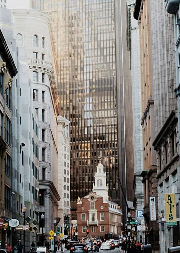 A bustling city street with cars and tall buildings in the background.