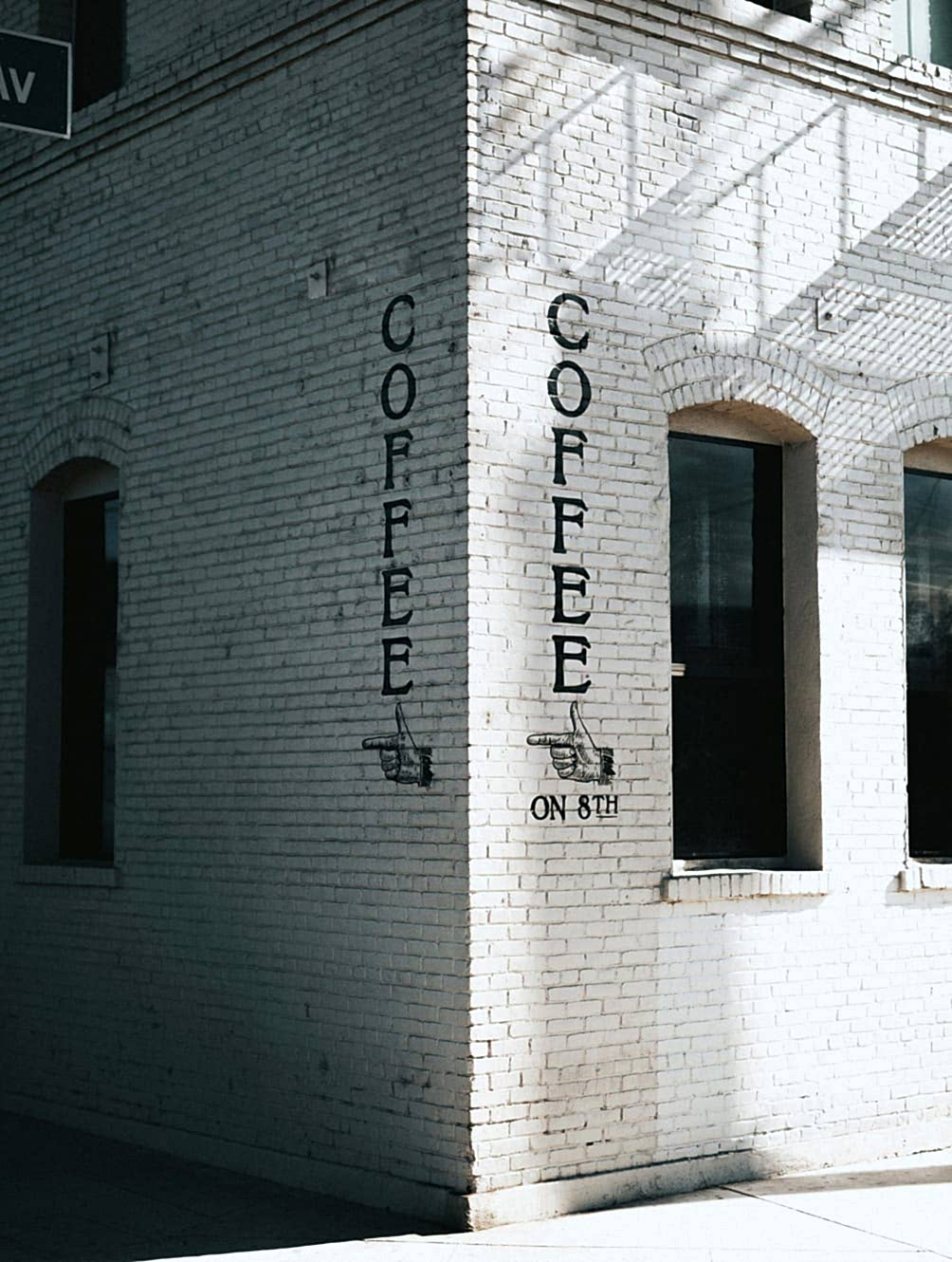 Classic white brick building featuring arched windows.