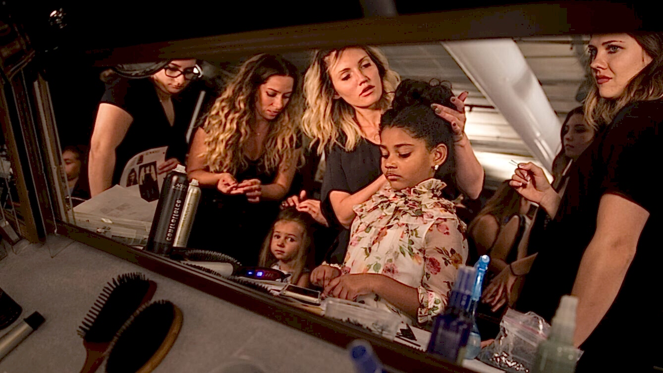 Young girl getting ready with beauty team surrounding her