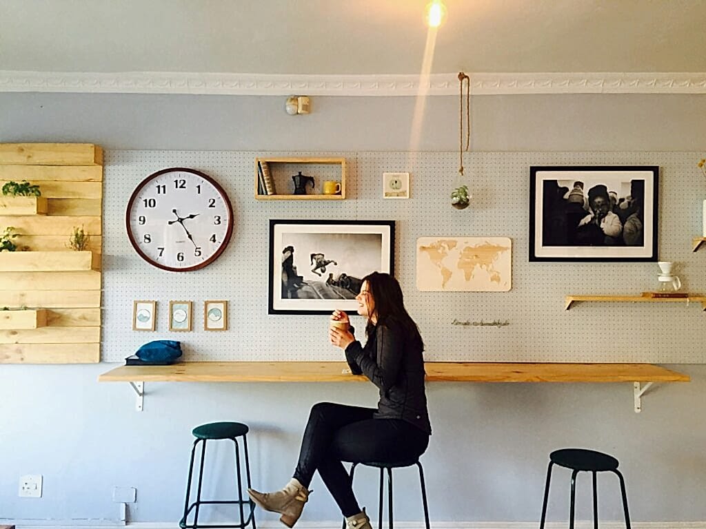 A woman laughing while sitting on a bar stool in a cafe