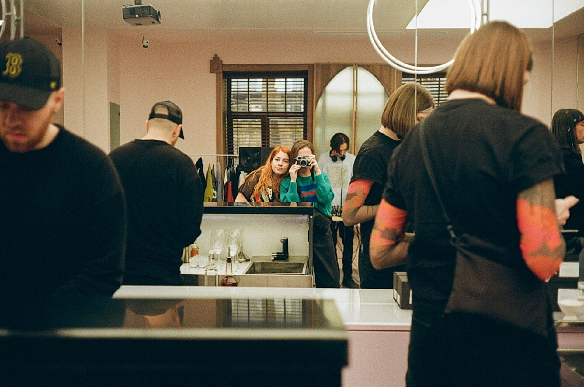 Girls taking a photo with a film camera in a mirror