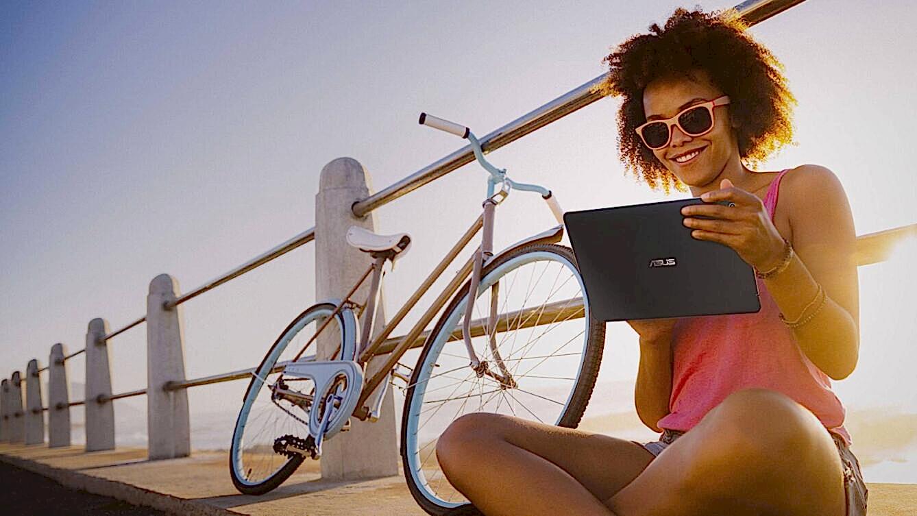 Person on Asus laptop sitting on pier with bike