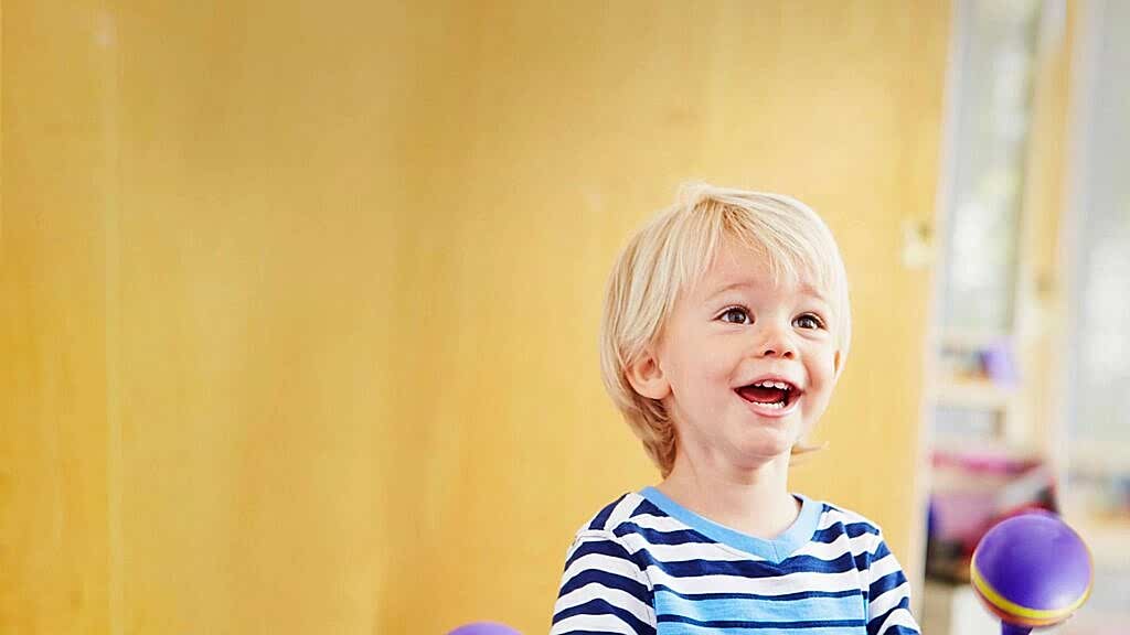 Child smiling in front of a bright colored background