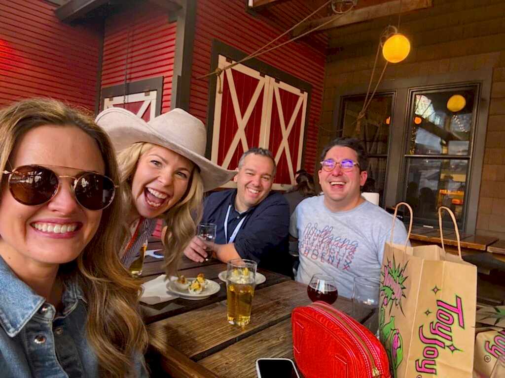 Amp employees smiling for a picture while sitting outside at a restaurant